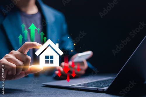 Financial interest rates and mortgage rates, businessman holding virtual home icon and up and down arrow symbol for calculate variable interest rates according to benchmarks. photo