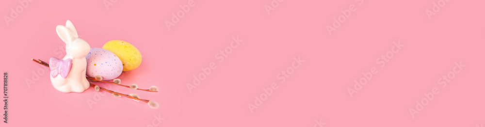 Spring easter holiday, decorative composition with willow branch, white statuette rabbit and colorful painted eggs on pastel light blue background. Isolated, front view, place for text Spring easter holiday, decorative composition with willow branch, white statuette rabbit and colorful painted eggs on pastel light blue background. Isolated, front view, place for text