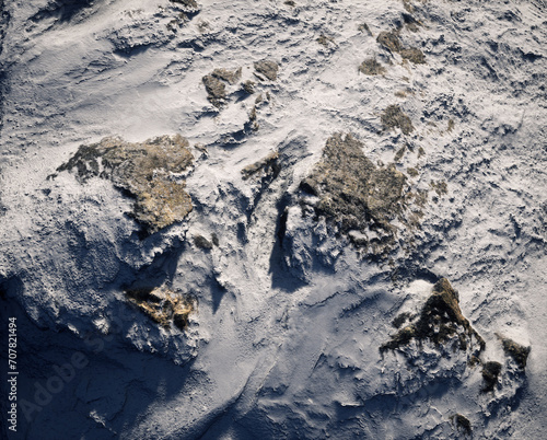 Aerial of rocky terrain covered in snow. © ysbrandcosijn
