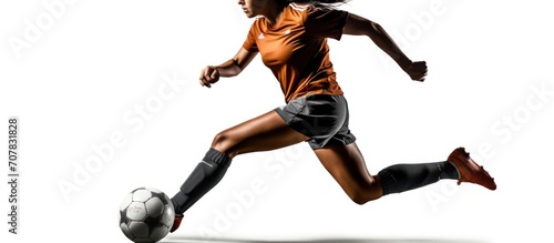 Young female soccer or football player with long hair in sportwear and boots kicking ball for the goal in jump on white background. © SULAIMAN