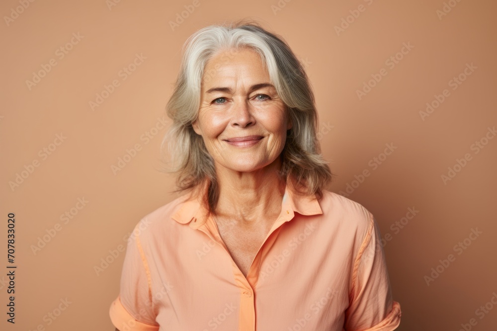 Portrait of smiling senior woman with grey hair on brown background. Portrait of smiling senior woman with grey hair on brown background.