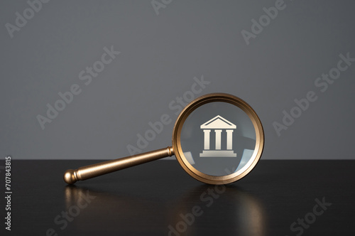 Magnifying glass and courthouse, college, university or government state. Legal research