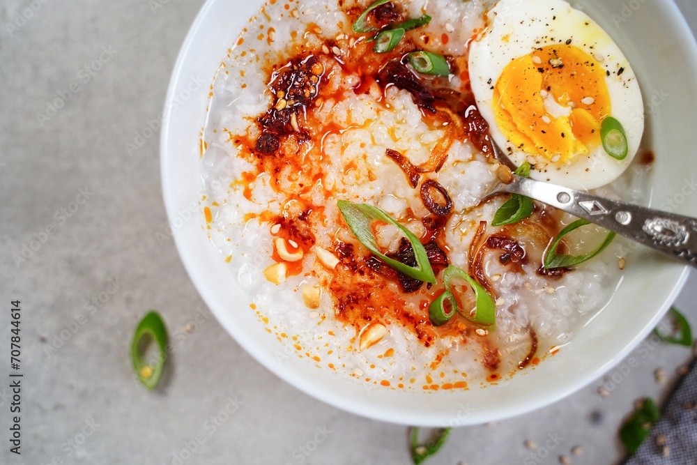 Homemade Asian Chinese style Congee with soft boild egg fried shallots and spring onions Homemade Asian Chinese style Congee with soft boild egg fried shallots and spring onions