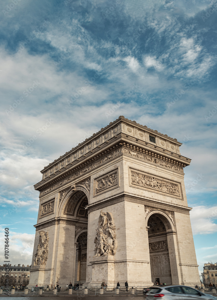Famous Arc de Triomphe (Triumphal Arch) at the city center of Paris and traffic trails in Chaps Elysees. Symbol of the glory and historical heritage, Iconic touristic architectural landmark, Tourism a