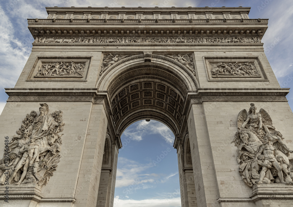 Famous Arc de Triomphe (Triumphal Arch) at the city center of Paris. Symbol of the glory and historical heritage, Iconic touristic architectural landmark, Tourism and travel concept. Selective focus.