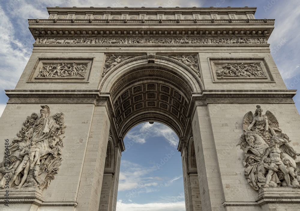 Famous Arc de Triomphe (Triumphal Arch) at the city center of Paris. Symbol of the glory and historical heritage, Iconic touristic architectural landmark, Tourism and travel concept. Selective focus. Famous Arc de Triomphe (Triumphal Arch) at the city center of Paris. Symbol of the glory and historical heritage, Iconic touristic architectural landmark, Tourism and travel concept. Selective focus.