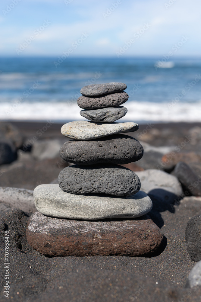 Volcanic rocks balance. Rocky beach on Canary Islands. Tenerife black beach. Small stones background. Atlantic ocean beach. Black and dark gray rocks Volcanic rocks balance. Rocky beach on Canary Islands. Tenerife black beach. Small stones background. Atlantic ocean beach. Black and dark gray rocks