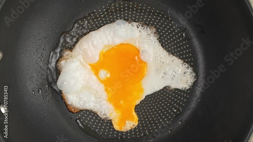 One egg fried in a frying pan top view. High quality 4k footage, Timelapse video of cooking a fried egg in a frying pan top view