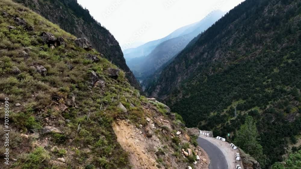 Aerial video of a road on the edge of a rocky mountain cliff, taken with a drone moving in the valley Aerial video of a road on the edge of a rocky mountain cliff, taken with a drone moving in the valley