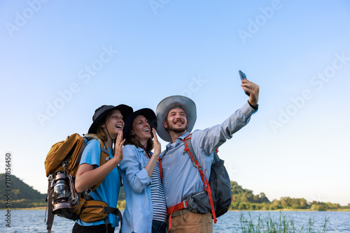 family caucasion with backpacks taking selfie by smartphone,