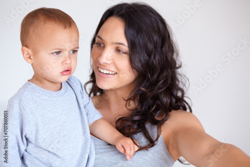 Mom holding toddler in bedroom with smile, bonding and child care with support in morning. Happy woman, baby boy and spending time together in home with development, trust and safety in mothers love.