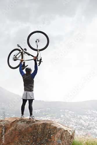 Back, success and a man with a bike on the mountains for training achievement or pride. Nature, fitness and a male biker on a cliff or hill with a bicycle for an exercise, fitness or competition win