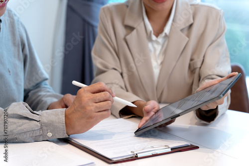 businesswoman Handing an electronic document on a tablet for a businessman to sign