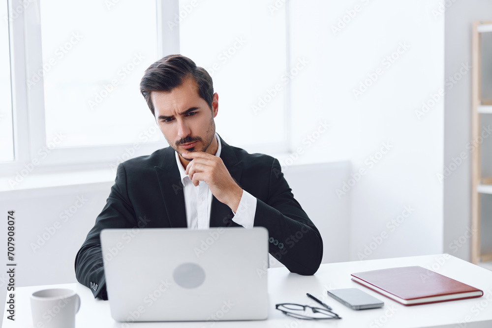 Indoors man sitting thinking business white laptop working computer desk businessman office tired Indoors man sitting thinking business white laptop working computer desk businessman office tired
