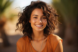Close up portrait of a beautiful young woman with curly hair smiling outdoors