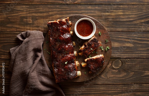 Barbecue pork ribs with dip sauce on cutting board