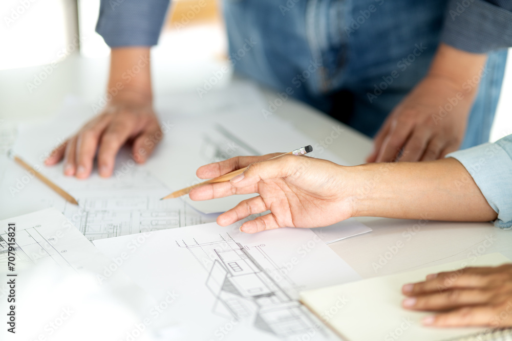 Architects and Engineers A man and woman are standing and sitting Architects and Engineers A man and woman are standing and sitting