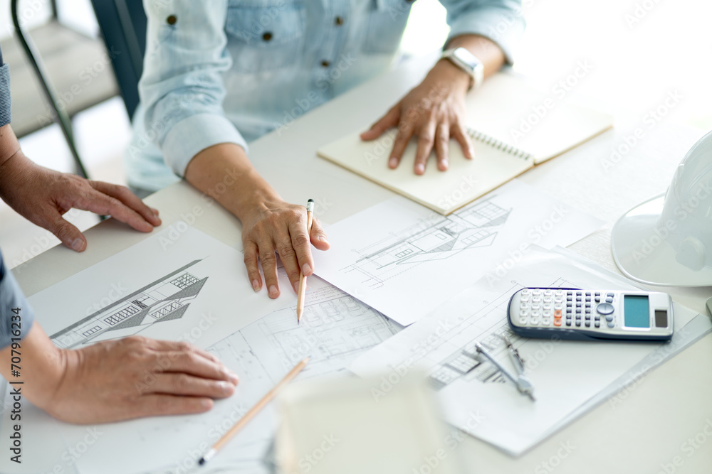 Architects and Engineers A man and woman are standing and sitting Architects and Engineers A man and woman are standing and sitting