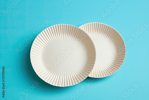 Biodegradable paper dishes on a blue background, environmentally friendly.
