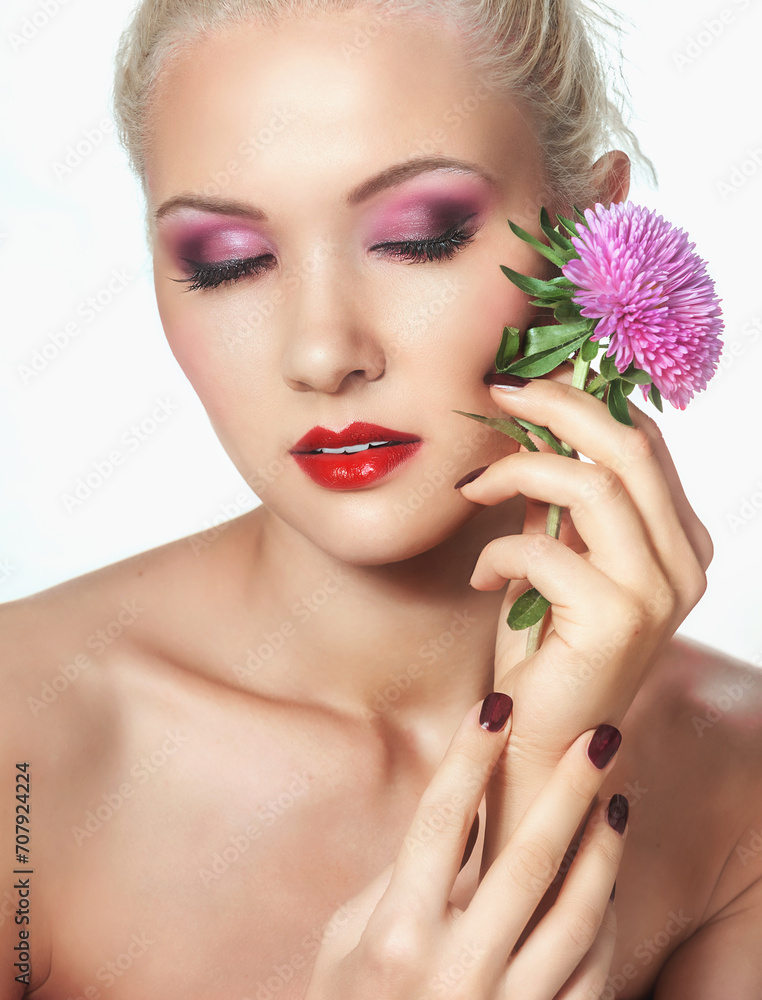 Close-up portrait of charming blonde woman with pink flower