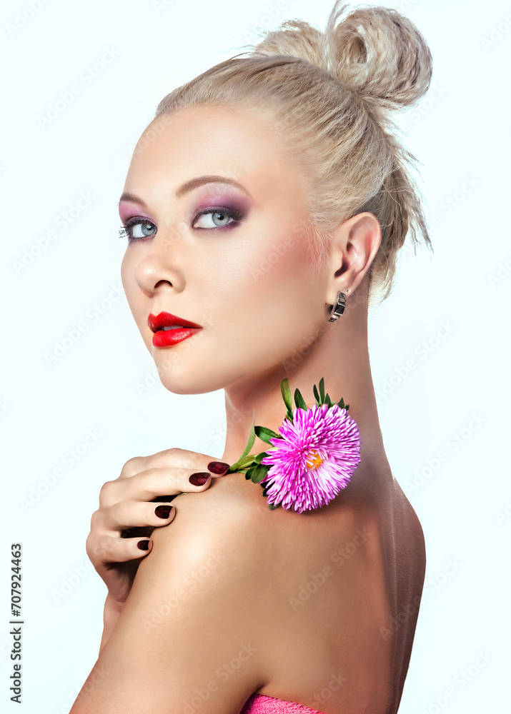 Close-up portrait of charming blonde woman with pink flower
