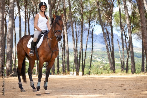 Portrait, horse riding or equestrian in countryside or nature with rider or jockey for recreation or adventure. Smile, pet or happy woman with an animal for training, exercise or wellness in forest
