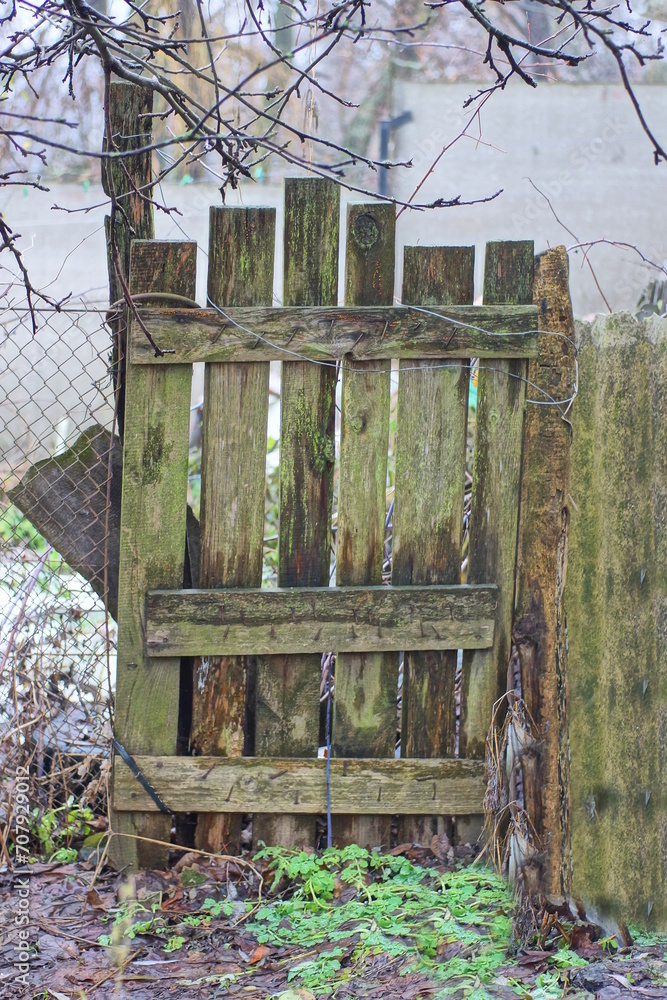 Φωτογραφία gray green rural wooden fence wall and closed old one door on the street