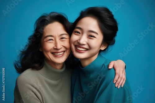 a young female asian hugs her mother