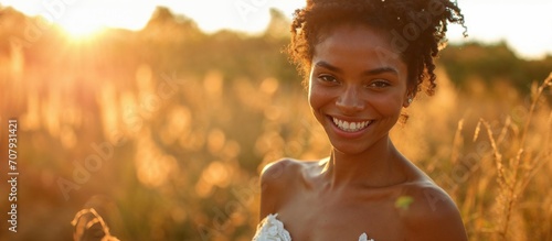 Beautiful african american bride in the field at sunset, smiling.