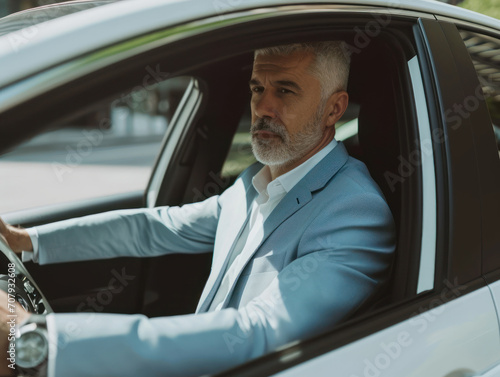 a happy stylish caucasian man in light blue suit is driving white car, Sale transport concept. © Svetlana