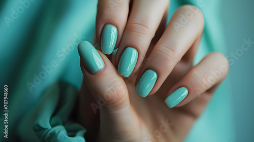 Elegant Woman s Hand with Mint Blue Nail Polish Over Matching Fabric Background