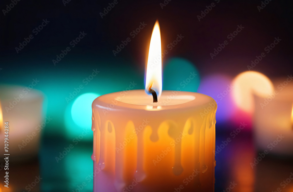 A lit candle with a blurred background of candles in the background A lit candle with a blurred background of candles in the background