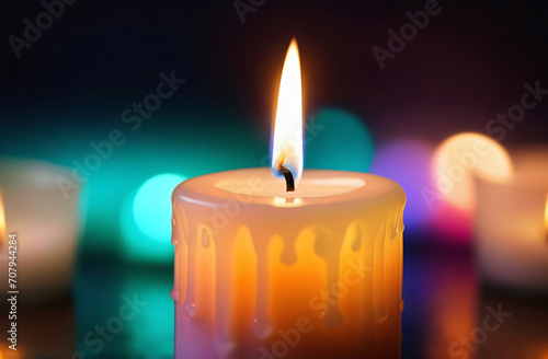 A lit candle with a blurred background of candles in the background