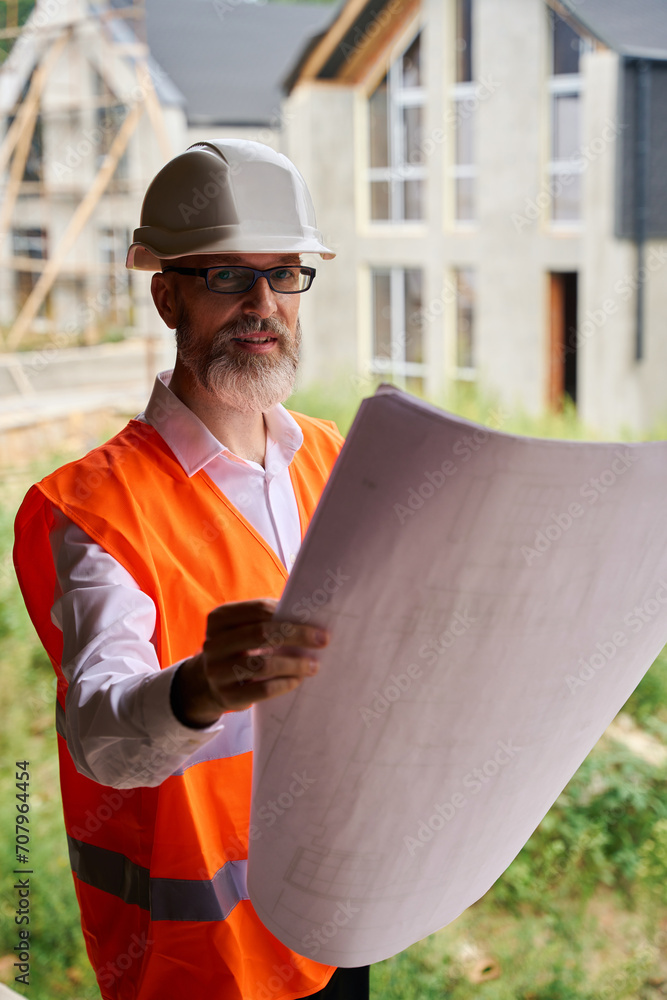Construction foreman using blueprints on building site Construction foreman using blueprints on building site