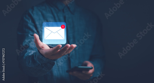 concept of email notification ,Business email communication, Internet technology ,online marketing . man shows envelope icon on hand. Show electronic message inbox notifications photo