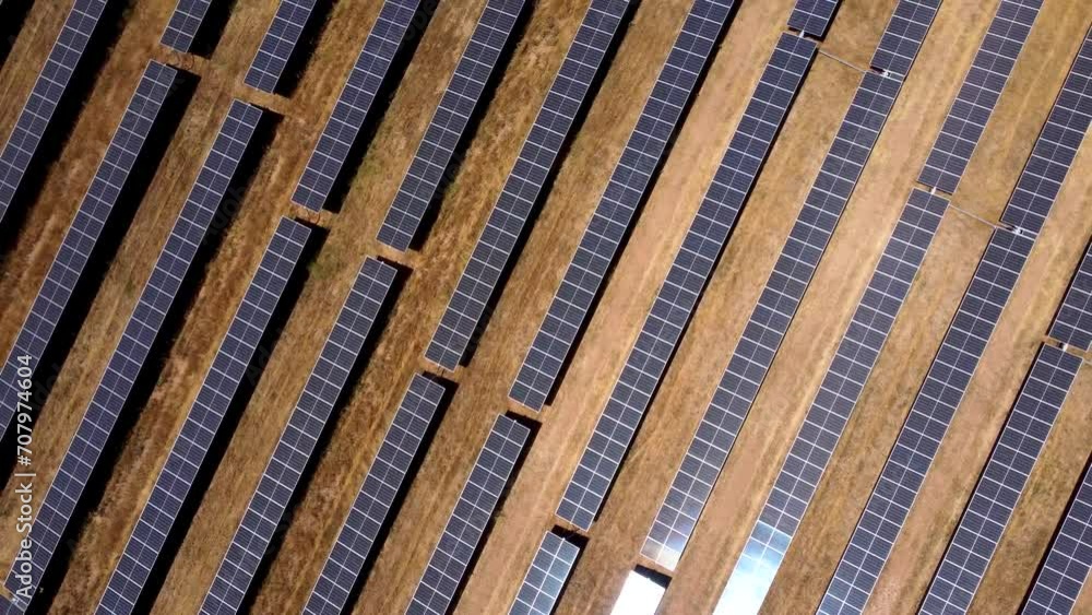 Top view of a solar farm. Rows of modern photovoltaic solar panels. Renewable ecological source of energy from the sun. Camera in tilt up position. Drone orbiting above the solar farm. Top view of a solar farm. Rows of modern photovoltaic solar panels. Renewable ecological source of energy from the sun. Camera in tilt up position. Drone orbiting above the solar farm.