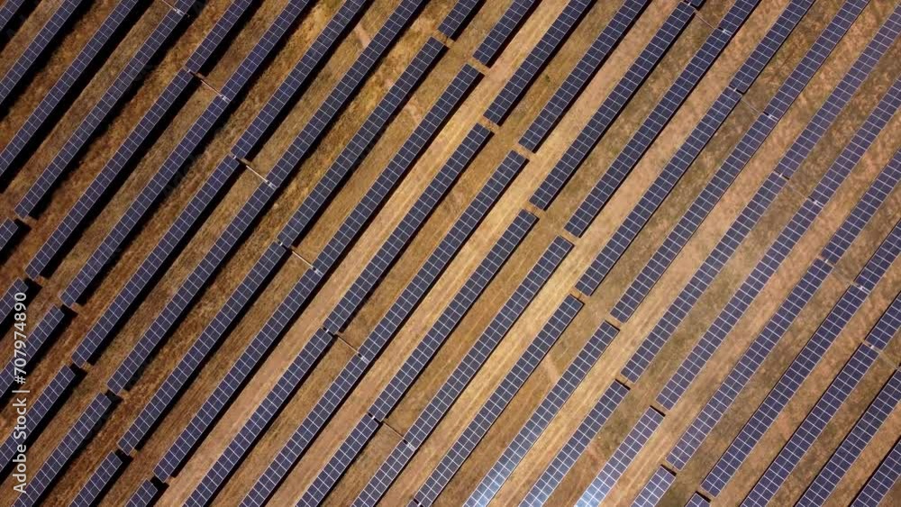 Top view of a solar farm. Rows of modern photovoltaic solar panels. Renewable ecological source of energy from the sun. Camera in tilt up position. Drone slowly descending. Top view of a solar farm. Rows of modern photovoltaic solar panels. Renewable ecological source of energy from the sun. Camera in tilt up position. Drone slowly descending.