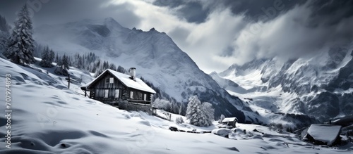 Winter scene in the Swiss Alps captures cabin amidst snowy landscape.