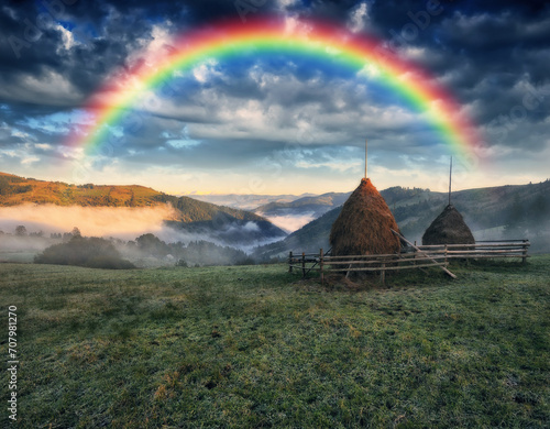 rainbow over the meadow in the Carpathian mountains. Fantastic landscape with rainbow. Dramatic overcast sky. Nature of Ukraine