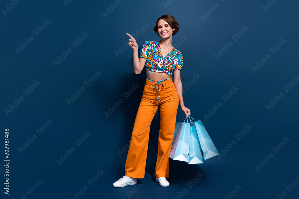 Φωτογραφία Full size photo of attractive young woman shopping bags point empty space wear t