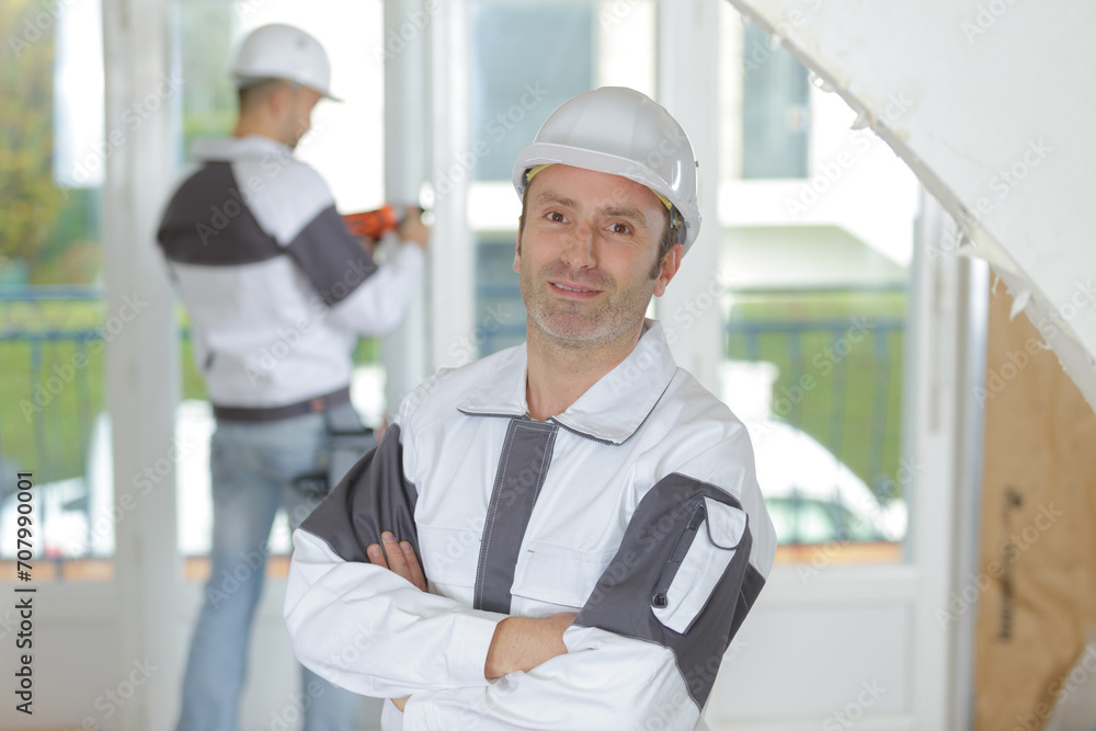 joyful builder smiling while standing indoors joyful builder smiling while standing indoors