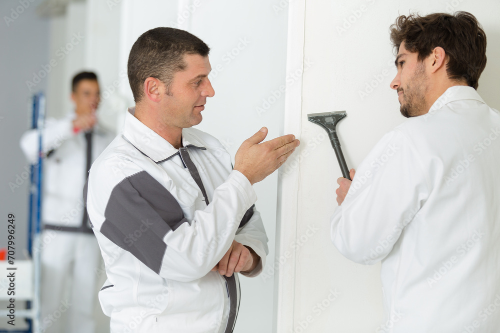 smiling young man cleaning white wall smiling young man cleaning white wall