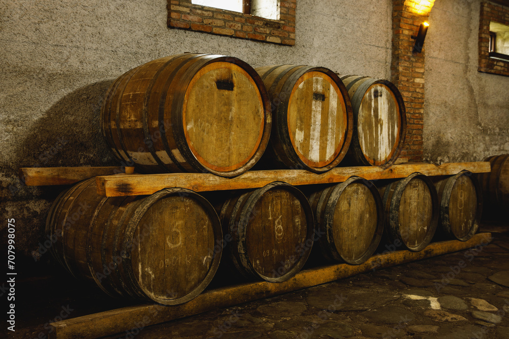Old wine cellar with wooden oak barrels.