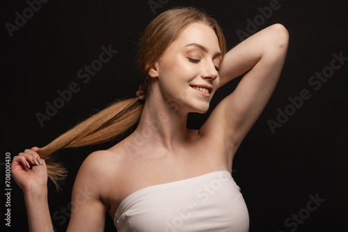 Beatiful portrait of a beautiful and gentle blonde girl on an isolated black background. Skin care