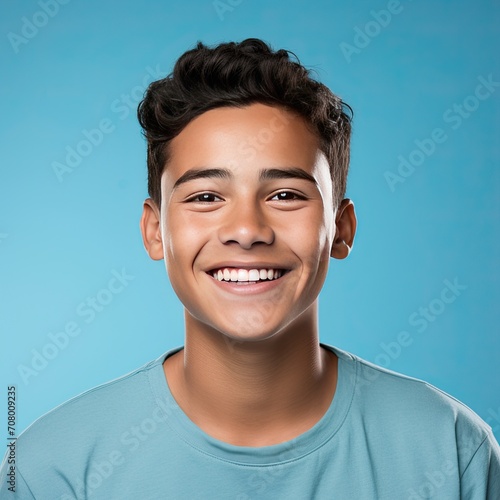 Portrait Headshot of a Happy Latino Hispanic Teenager Boy on a Light Blue Background