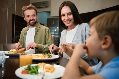 Couple looking at their son with smiles while having festive breakfast in hotel
