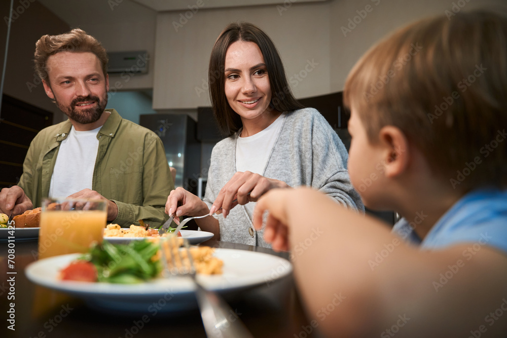Man and woman having breakfast with their son while celebrating winter holidays Man and woman having breakfast with their son while celebrating winter holidays