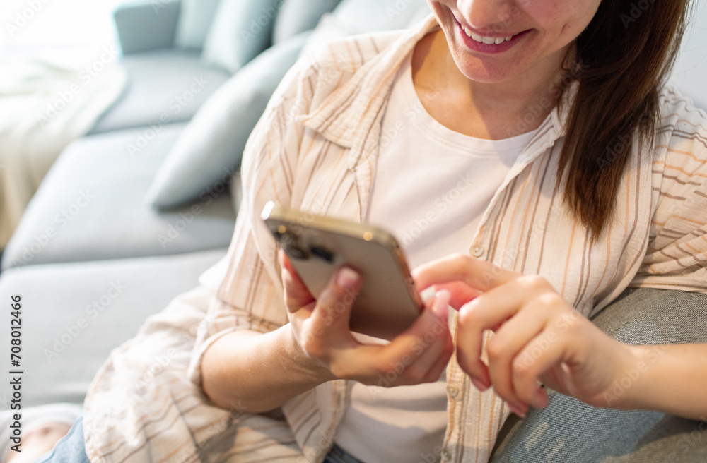 Close up woman sitting on couch using smartphone at home Close up woman sitting on couch using smartphone at home