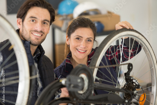 male and female repairer working in bicycle workshop