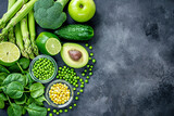 Green various vegetables and fruits on dark background